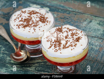 Zwei traditionelle Erdbeer Trifle Desserts mit frischer Sahne und bestreut mit Schokolade Stockfoto