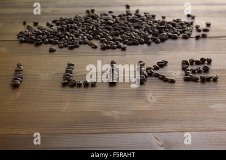 Kaffeebohnen-Inschrift auf dem Holztisch Stockfoto