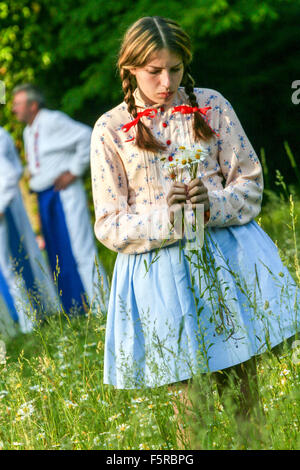Frau mit Margeriten. Teilnehmer der traditionellen Flammenstrahlen Gras auf der Wiese Schloss Buchlovice, Süd-Mähren, Tschechische Republik Stockfoto