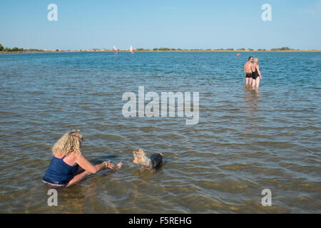 Paddeln mit einem Hund in kühle Nass auf Mittelmeer Küste in der Nähe von Stadt von Gruissan, in der Nähe von Narbonne, Südfrankreich, Frankreich. Stockfoto