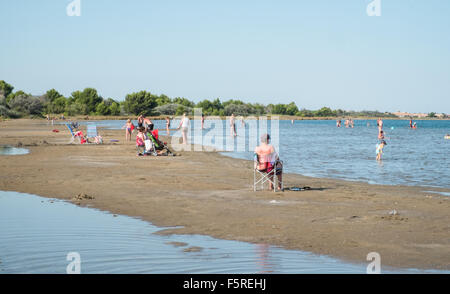 Sonnenbaden auf einem Sand spucken auf Mittelmeer Küste in der Nähe von Stadt von Gruissan, in der Nähe von Narbonne, Südfrankreich, Frankreich. Stockfoto