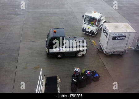 Flughafen Gepäckabfertigung Fahrzeuge vor Ort am Flughafen Heathrow in England. Stockfoto