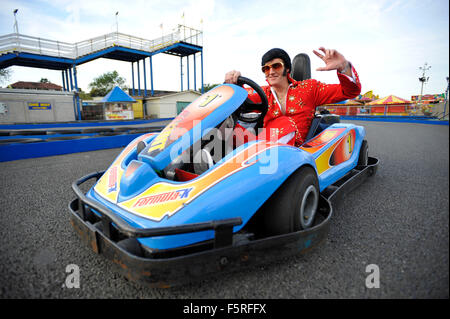 Ein Elvis-Imitator reitet ein Go-Kart auf Coney Beach Amusement Park in Porthcawl, South Wales während des jährlichen Elvis Festival. Stockfoto