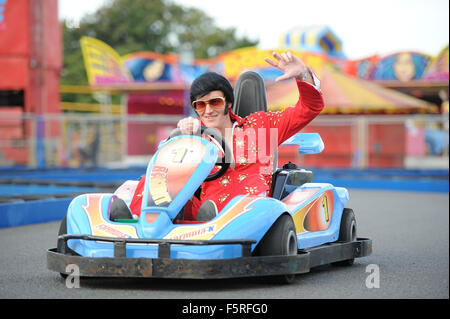 Ein Elvis-Imitator reitet ein Go-Kart auf Coney Beach Amusement Park in Porthcawl, South Wales während des jährlichen Elvis Festival. Stockfoto