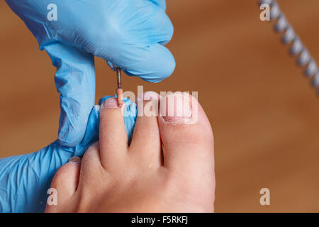 Meister Pediküre formt die Nägel und Nagelhaut. Hardware-Maniküre. Konzept-Körperpflege. Stockfoto