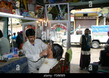 Delhi, Indien - April 30,2004: ein Friseur, eine saubere Rasur an dem Kunden in seinem kleinen Laden in Delhi geben. Stockfoto