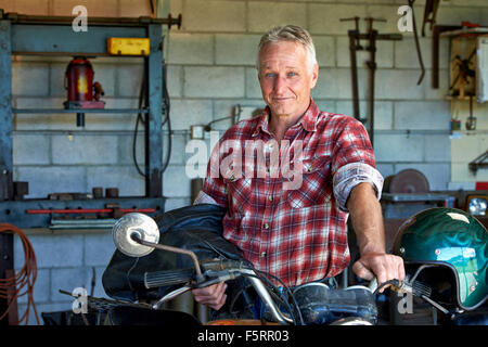 Porträt von einem reifen Alter Mann mit seinem Motorrad. Stockfoto