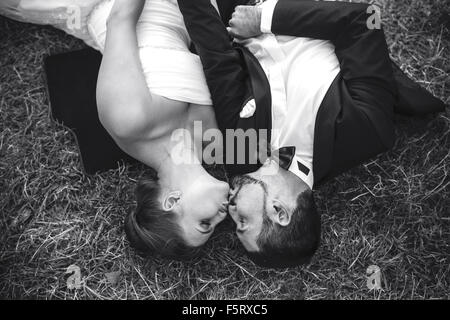 Hochzeitspaar auf der Wiese liegend Stockfoto