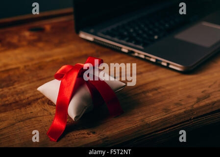 Büro-Jubiläums-Überraschung für Mitarbeiter, gewickelt auf hölzernen Schreibtisch mit Laptop-Computer im Hintergrund, selektiven Fokus vorhanden Stockfoto