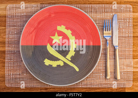 Teller mit der Flagge Angolas drauf für Ihre internationale Speisen und Getränke-Konzepte. Stockfoto