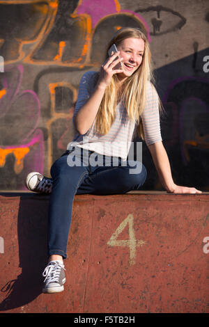 Teenager-Mädchen telefonieren mit Handy auf Spielplatz Stockfoto