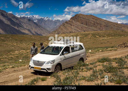 Indien, Himachal Pradesh, Spiti, Langza, Fahrer und Guide mit Toyota Innova Auto unter jetzt gekleidet Berge Stockfoto