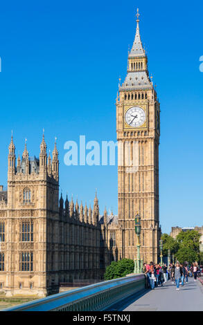 Touristen zu Fuß vorbei an Big Ben und die Houses of Parlament in Westminster Brücke Stadt London England GB UK EU Europas Stockfoto