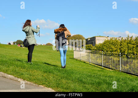 Zwei japanische TouristInnen fotografieren auf Plymouth Hacke, Devon, England Stockfoto