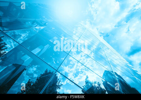 Blau getönten Foto von Wolkenkratzern Spiegelung im Glas gegen Sonne, betriebswirtschaftlichen Hintergrund. Stockfoto