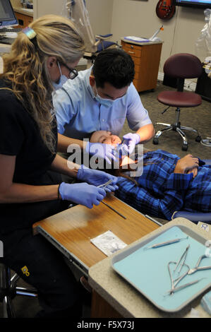 Ein Kieferorthopäde ist ein Zahnarzt, spezialisiert auf schiefe Zähne begradigen. Hier mit Assistenten und Patienten im Büro. Stockfoto