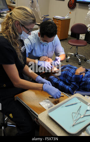 Ein Kieferorthopäde ist ein Zahnarzt, spezialisiert auf schiefe Zähne begradigen. Hier mit Assistenten und Patienten im Büro. Stockfoto