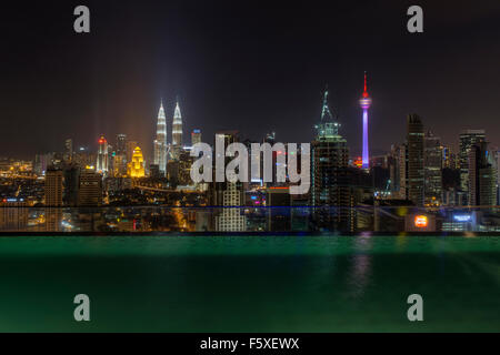 Kuala Lumpur Skyline bei Nacht mit einem Luxus-Pool im Vordergrund Stockfoto