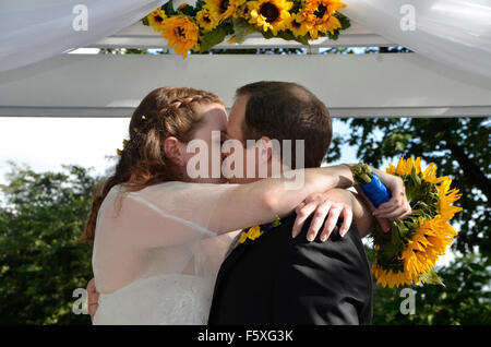Mann und Frau haben einen leidenschaftlichen Kuss bei ihrer Hochzeit Stockfoto