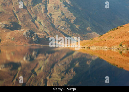 Herbstfärbung von den umliegenden Fells reflektiert auf die Oberfläche des Crummock Wasser, Lake District, Cumbria, UK Stockfoto
