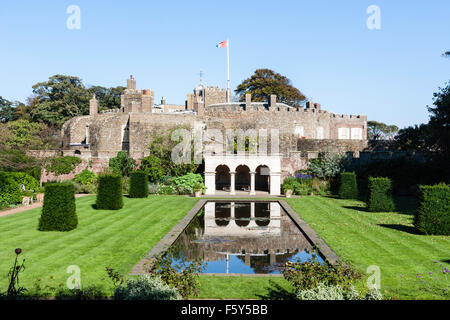 England, Walmer Castle. Die Königin Mutter Garten', Teich und leere Sitzplätze Pavillon mit der Tudor Schloss im Hintergrund. Blue Sky. Stockfoto