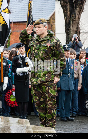 England, Ramsgate. Tag der Erinnerung. Senior Offizier camouflage tragen einheitliche Salutierte am Kriegerdenkmal während der Zeremonie im Regen. Stockfoto