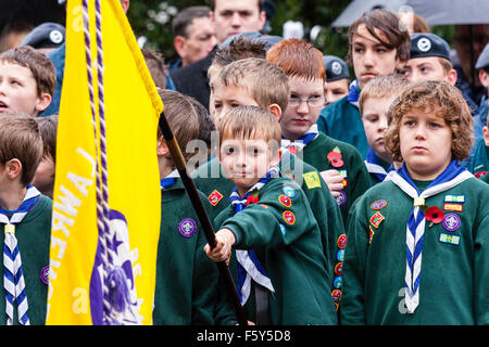 England. Tag der Erinnerung. Pfadfinder, klatschnass im strömenden Regen, ständigen Aufmerksamkeit, einer Holding und senken eine gelbe Flagge. Auge - Kontakt. Stockfoto