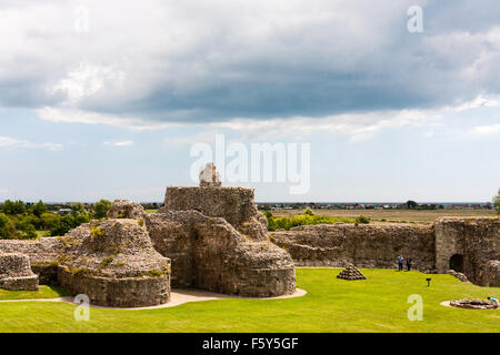 England, Pevensey Castle. Norman Schloss innerhalb der Römischen Saxon Shore fort gebaut. Ruine des Bergfrieds Basis und Grundlagen der Türmchen Eingang. Grauer Himmel. Stockfoto