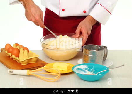 Teig mischen. Gugelhupf mit Schokoladenglasur machen. Stockfoto