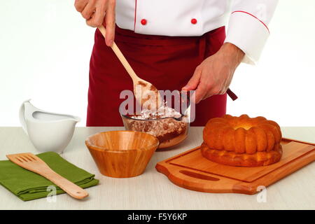Kakao und Puderzucker mischen. Schokoladenglasur für Gugelhupf machen. Stockfoto