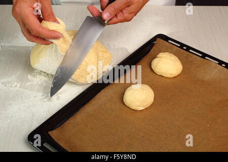 Teig schneiden und Umformen Brötchen. Herstellung von Hefe-Brötchen-Brötchen Stockfoto