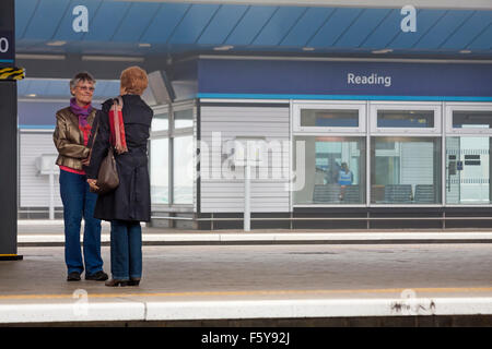 Zwei Frauen stehen auf Plattform sprechen Lesung Bahnhof im November Stockfoto