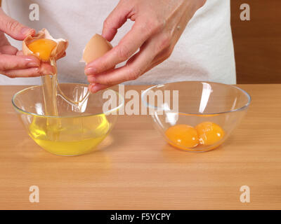 Trennen Eigelb von weiß. Herstellung von Schokolade Schicht Kuchen mit Frischkäse-Füllung und Schokoladenglasur. Serie. Stockfoto