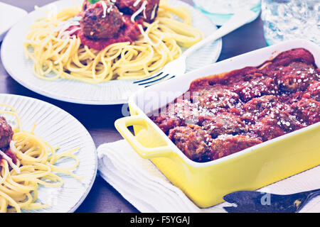 Hausgemachte italienische Fleischbällchen garniert mit Koriander und Parmesan-Käse über Spaghetti zum Abendessen. Stockfoto