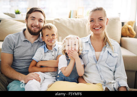 Happy Family im Casualwear zu Hause entspannen Stockfoto