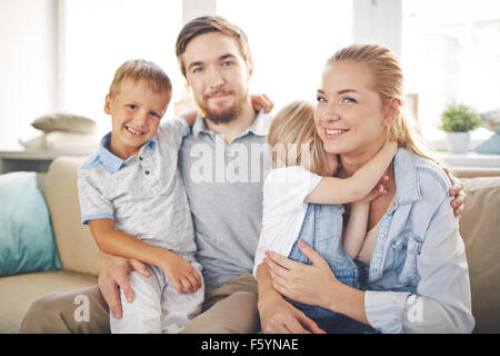 Junges Paar mit ihren niedlichen Kinder die Erholung zu Hause Stockfoto