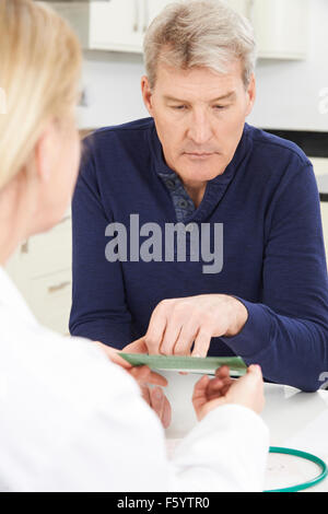 Reifer Mann Lesung Broschüre In Arztpraxis Stockfoto