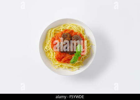 Teller mit Spaghetti und Fleischbällchen in Tomatensauce auf weißem Hintergrund Stockfoto