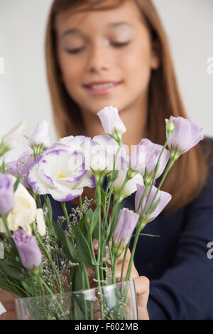 Hübsche Mädchen, die Blumen riechen Stockfoto