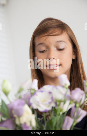 Hübsche Mädchen, die Blumen riechen Stockfoto