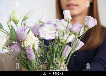 Hübsche Mädchen, die Blumen riechen Stockfoto