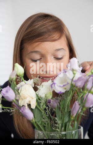 Hübsche Mädchen, die Blumen riechen Stockfoto