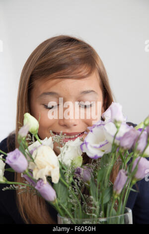 Hübsche Mädchen, die Blumen riechen Stockfoto