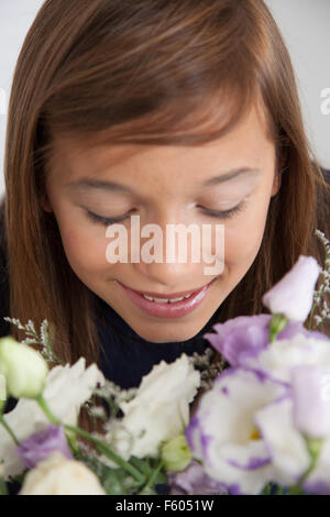 Hübsche Mädchen, die Blumen riechen Stockfoto