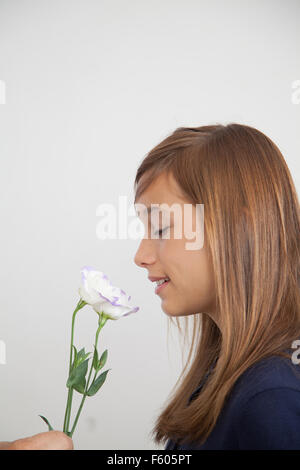 Hübsche Mädchen, die Blumen riechen Stockfoto