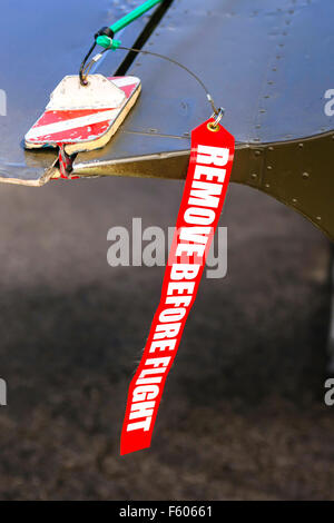 Entfernen Sie vor dem Flug rot und weißen Tag angebracht, ein Aufzug Unterlegkeil auf einer Ebene Stockfoto