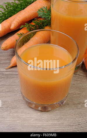 Glas Karottensaft mit Karotten auf den Tisch Stockfoto