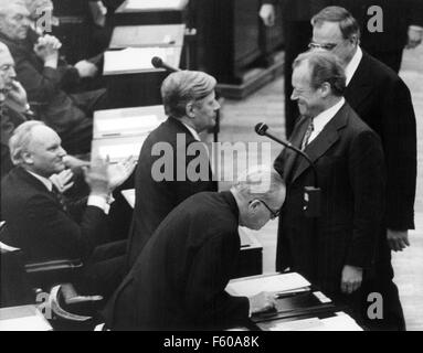 SPD-Vorsitzende Willy Brandt (R) gratuliert Helmut Schmidt (Mitte) nach seiner Wiederwahl als Kanzler am 15. Dezember 1976 im Deutschen Bundestag in Bonn. Herbert Wehner in der Front. Helmut Kohl hinter Brandt. Stockfoto