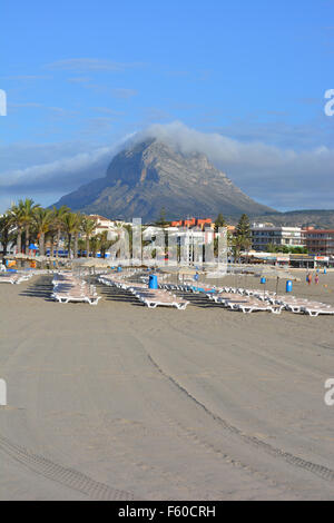 Frühmorgens am Arenal Strand, Javea, Costa Blanca, mit Liegestühlen im Vordergrund und Montgo Berg im Hintergrund. Stockfoto