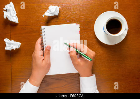 der Autor schreibt in einem Notizbuch Ihre Gedanken in den Frame Händen nur Stockfoto